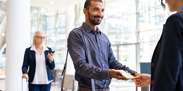 a business man in an airport showing his passport to TSA